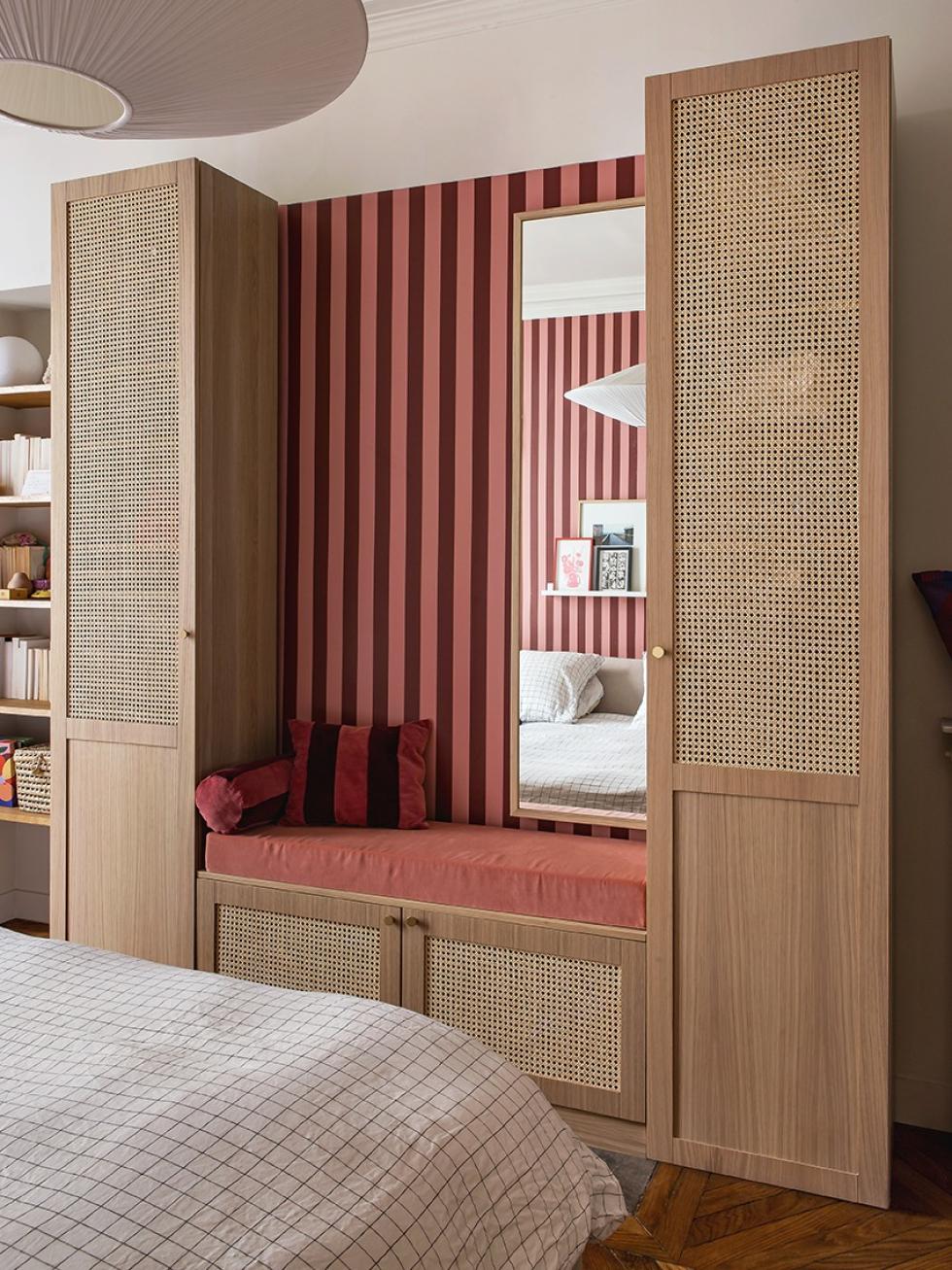 Das Schlafzimmer von Lisa Gachet, mit bordeauxroter und rosafarbener Tapete, und einem Kleiderschrank aus Flechtdesign und Eiche Natur.