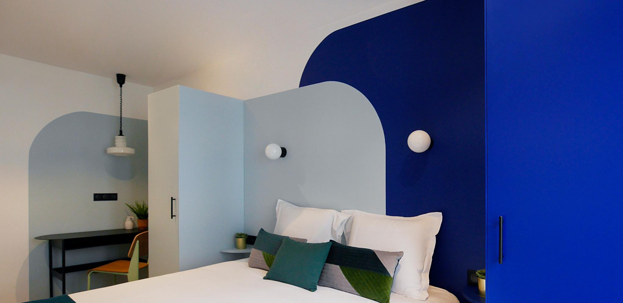 Mattlackierte Sitzbank mit Flechtwerk & Sockelleiste aus Messing, gemalter Bogen an der Wand