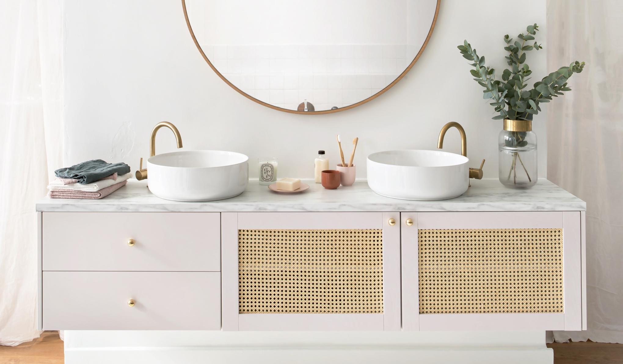 Hängender Badezimmerschrank mit Fronten aus rosa-beigefarbenem Rohrgeflecht und Messingaccessoires